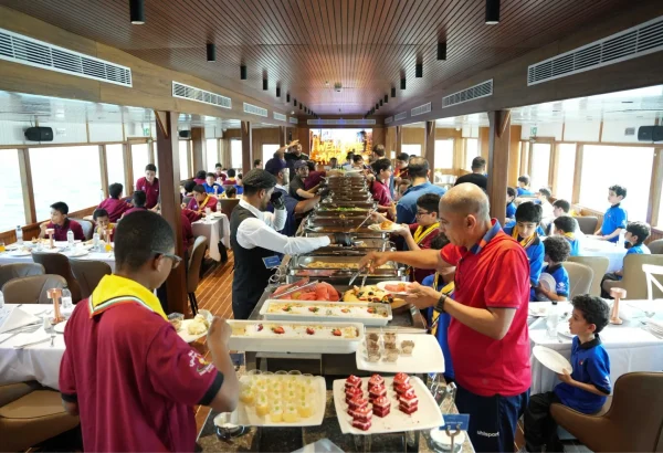 School students enjoying buffet lunch on Celeste dinner cruise Dubai Marina.